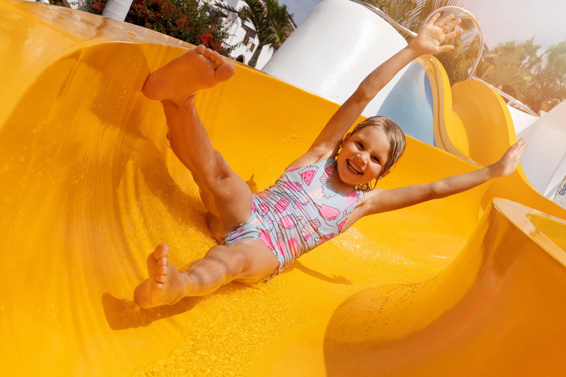 child riding water slide smiling