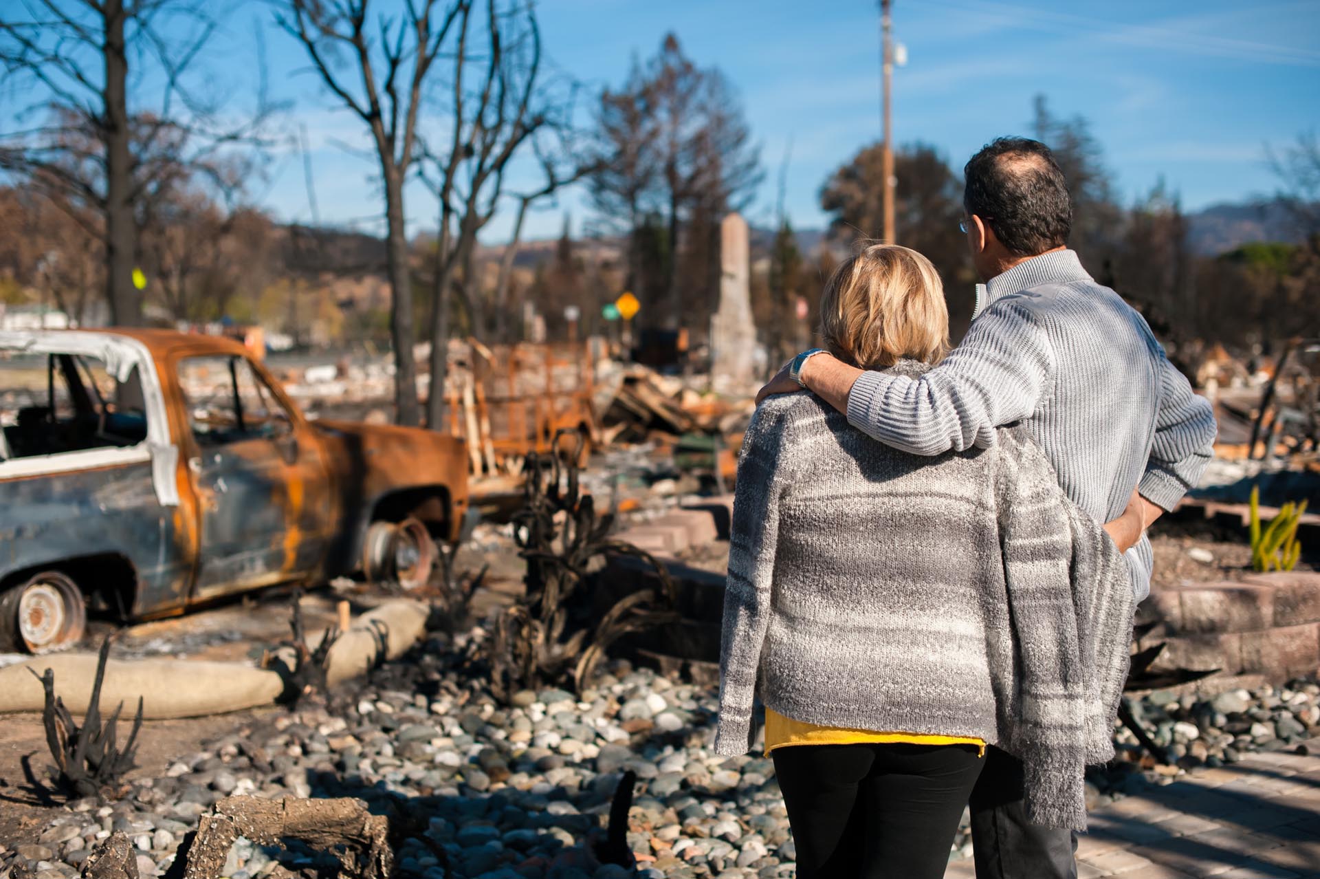 couple overlooking wildfire destruction