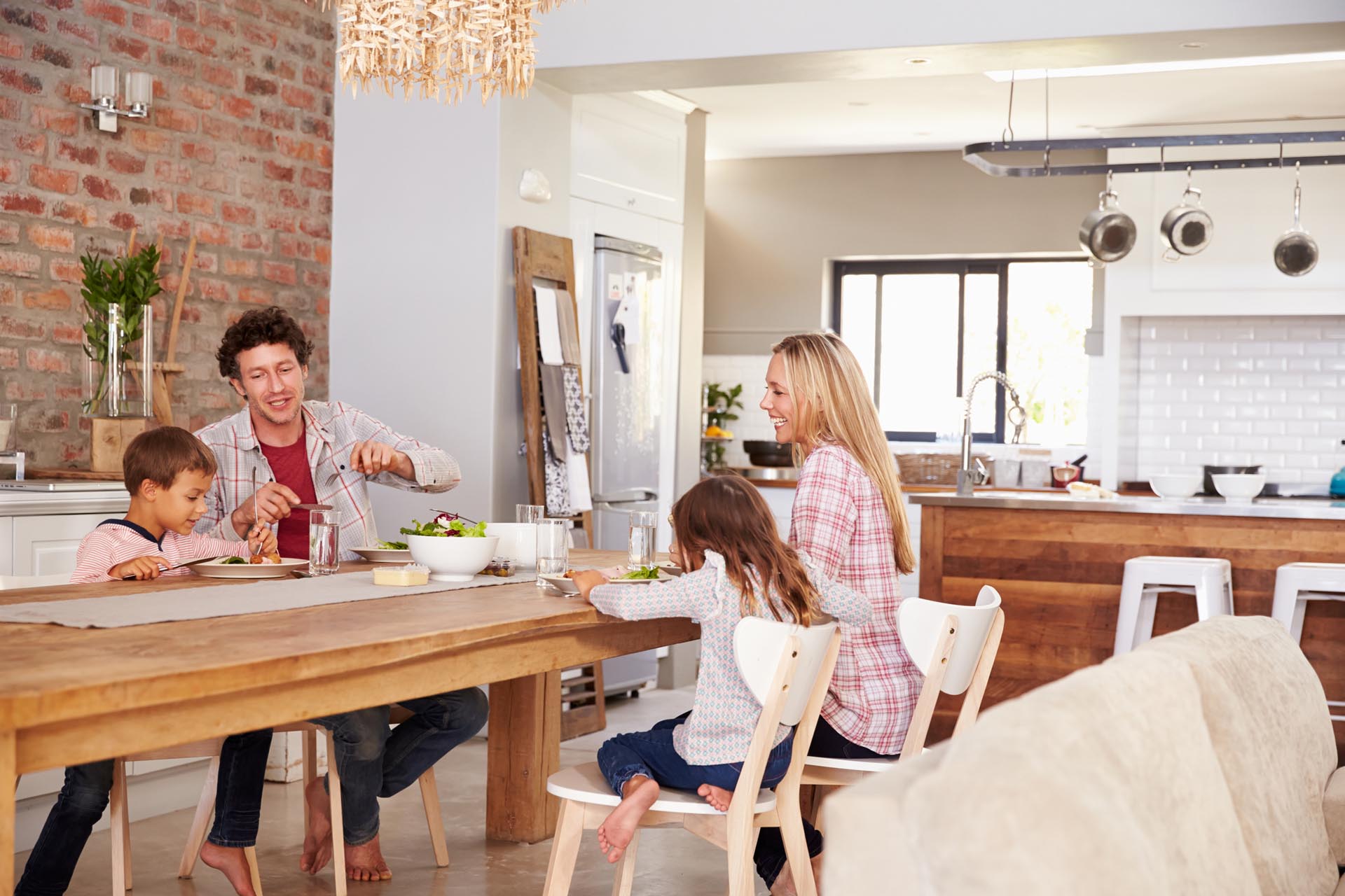 family eating dinner at wooden dining table