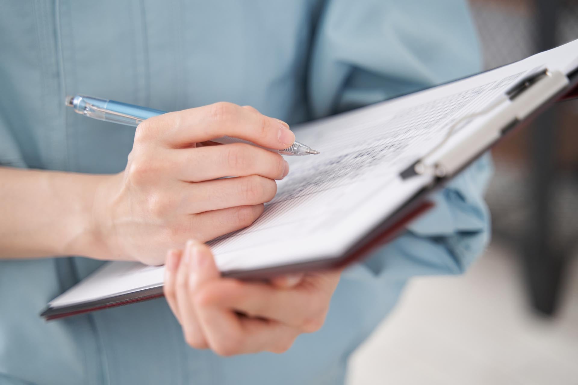 woman signing document on clipboard