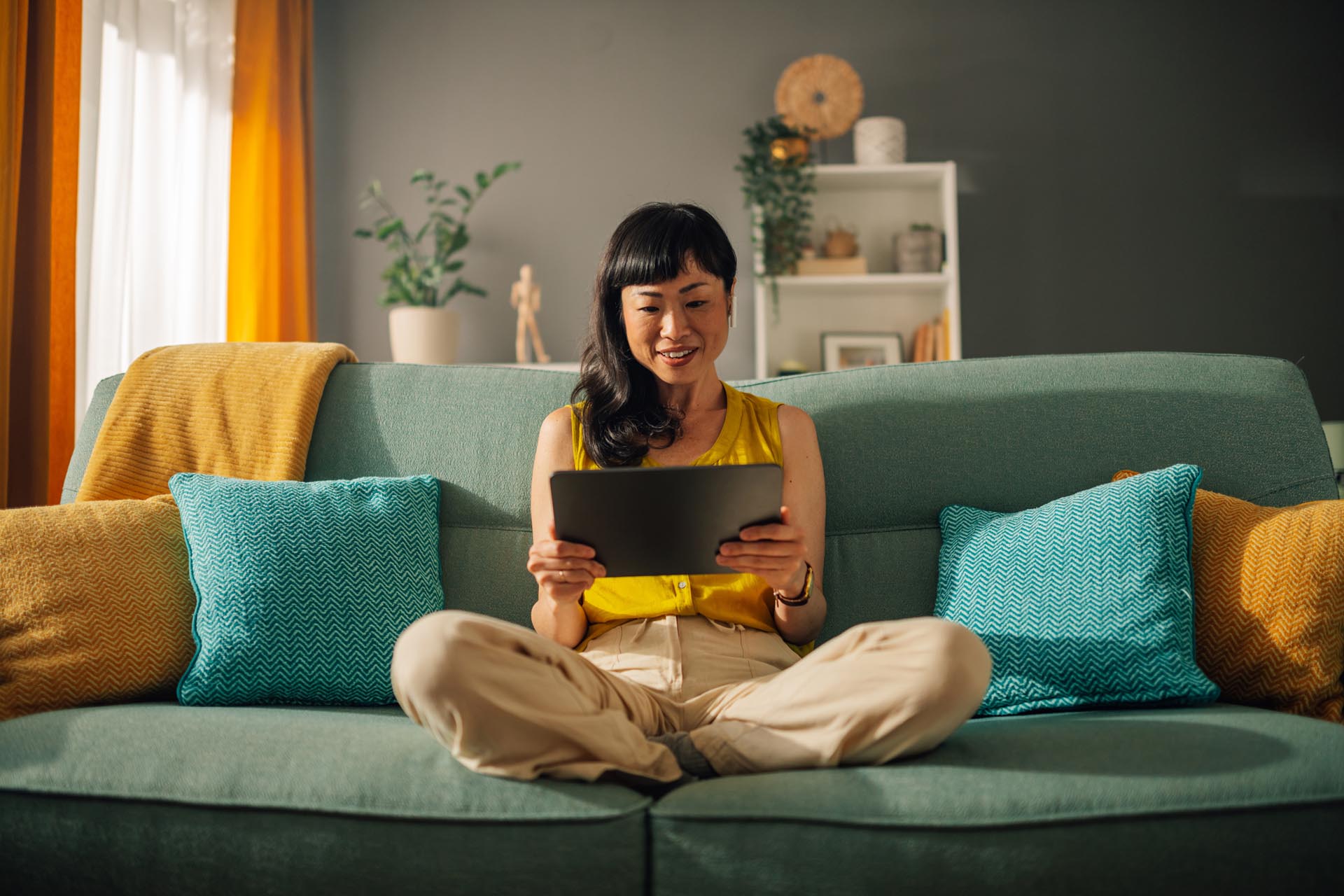 woman sitting on couch with tablet